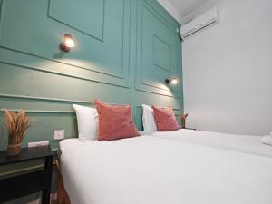 two beds in a room with blue walls and a table at Cosy room 6 in Tal-Pietà