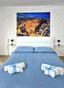 a bedroom with a blue bed with towels on it at Sa domu pitticca Cavour in Cagliari