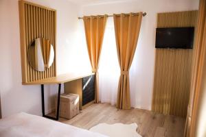 a bedroom with curtains and a mirror and a bed at Mera House Bilbor in Bilbor