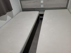 a bedroom with two beds in a room at Bungalow le Sartène in Lumio +1 photo