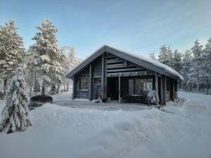 a cabin in the snow with a pile of snow at Hietavilla Pläk- Hot tube - Sauna - AC - Fireplace - 11kW EV-refuel - Landscape view - Silence - Free WiFi in Ruka
