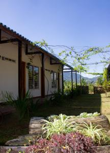 a house with a garden in front of it at Villa Celia Casa Campo in Pueblo Bello