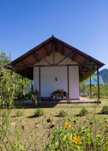 a pavilion with a table and a bench in a field at Villa Celia Casa Campo in Pueblo Bello