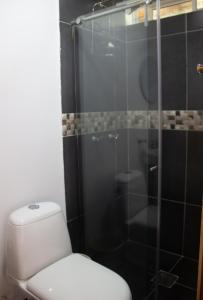 a bathroom with a toilet and a glass shower at Villa Celia Casa Campo in Pueblo Bello