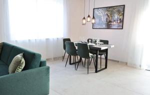 a dining room with a table and a green couch at Apartments Kellergasse in Purbach am Neusiedlersee +24 photos