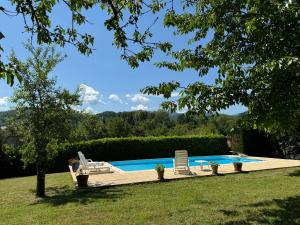 a swimming pool with two chairs and a table and a person at Velo Ariege Pyrenees in La Bastide-de-Sérou +23 photos