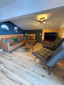 a large living room with a couch and a television at Apartments Chalet Sonnentanz in Piesendorf