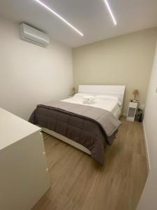a bedroom with a large bed in a white room at AmaRé House in Bari +8 photos