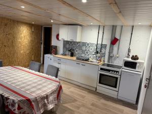 a kitchen with white appliances and a table with chairs at Le souplex d'Anaïs in Schirmeck