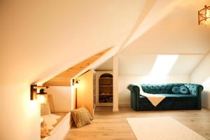 a living room with a blue couch in the attic at Mera House Bilbor in Bilbor