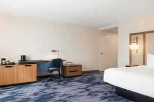 a hotel room with a bed and a desk and a chair at Fairfield by Marriott Inn & Suites Clinton in Clinton
