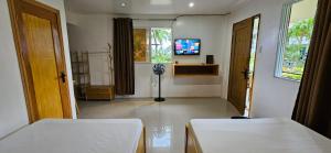 a room with two beds and a television in it at Vhora Inn Sibuyan in Magdiwang