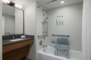 a bathroom with a blue chair sitting next to a bath tub at Fairfield by Marriott Inn & Suites Clinton in Clinton +23 photos