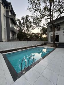 a swimming pool in front of a building at Atishay Villa I 4BHK I Pure veg I Pvt Pool & lawn in Lonavala