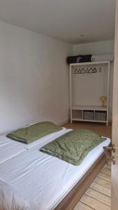 a bedroom with a white bed with a green blanket at Historische Villa mit Drachenfels-Blick in Bad Honnef am Rhein