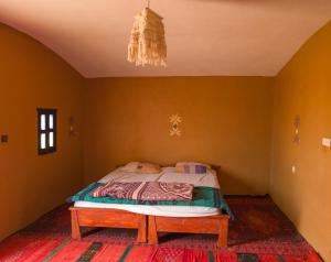 ein Schlafzimmer mit einem Bett in einem Zimmer mit einem Kronleuchter in der Unterkunft Sahara Peace camp in Zagora