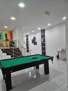 a pool table in the middle of a room with stairs at Hotel Manoá Poa - Ambiente acolhedor e humanizado, seu refúgio estratégico no centro de Poa, próx a UFRGS, rodoviária e a Santa Casa in Porto Alegre