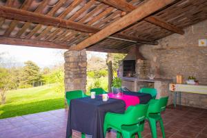 a patio with a table and green chairs at Complex Rural Can Caubet in Berga
