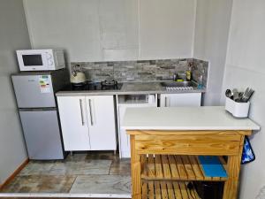 a small kitchen with a white refrigerator and a sink at Elmscote Cottages - Cabin 2 in Krugersdorp
