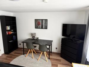 a dining room with a table and two chairs and a television at Apartment im Gründle in Birkenfeld