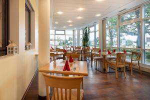 a restaurant with tables and chairs with red napkins on them at XZLLENZ light, Parken, 24h digitaler Check In und Zugang in Oberasbach