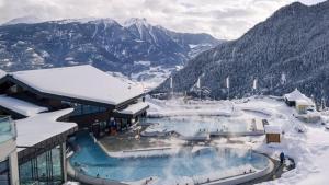 a resort with a pool in the snow on a mountain at Centre Thermal 2 chambres studio EV110 in Ovronnaz