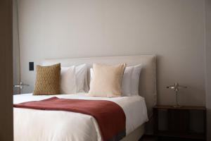 a large bed with white sheets and pillows at Stadtloft Suites Cham-Zug in Cham