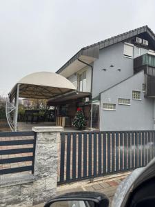 a house with a porch with a fence at Banja Luka Arcadia in Banja Luka