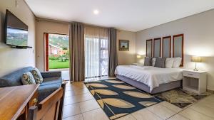 ein Schlafzimmer mit Bett, Fernseher und Sofa in der Unterkunft Botleng Guest House in Maseru