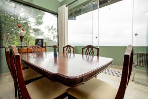 a dining room with a wooden table and chairs at Mystay in Kandy