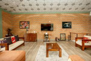 a living room with a couch and a tv on a brick wall at Mystay in Kandy