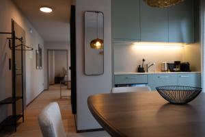 a dining room with a table and chairs and a kitchen at Stadtloft Suites Cham-Zug in Cham +48 photos