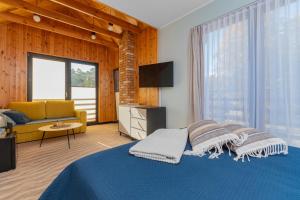 a bedroom with a blue bed and a couch at Wiatr od morza Jantar - BursztynoveLove in Jantar