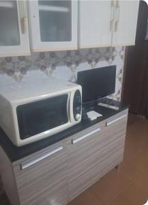 a microwave sitting on top of a counter in a kitchen at Quartos para locação in Mongaguá
