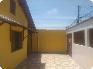 an empty room with a yellow wall and a building at Quartos para locação in Mongaguá +4 photos