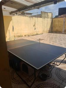 a ping pong table sitting on top of a building at Quartos para locação in Mongaguá