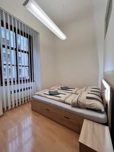 a bed in a room with a large window at Relax apartmá Brno central - Brno střed in Brno