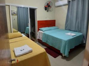 a hotel room with two beds and a mirror at Hotel los 4 Tesoros in Pedernales +5 photos