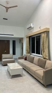 a living room with a couch and a coffee table at Atishay Villa I 4BHK I Pure veg I Pvt Pool & lawn in Lonavala
