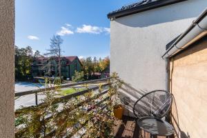 a balcony with a table and a chair on a building at Wiatr od morza Jantar - BursztynoveLove in Jantar