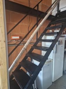 a metal staircase in a room with a wall at Chambre indépendante Pyrenées in Lombez +1 photo
