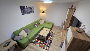 a living room with a green couch and a table at Dom Hlohovec Center in Hlohovec
