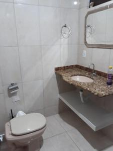 a white bathroom with a toilet and a sink at Tranquility with convenience in Caxambú Tranquilo in Caxambu +11 photos