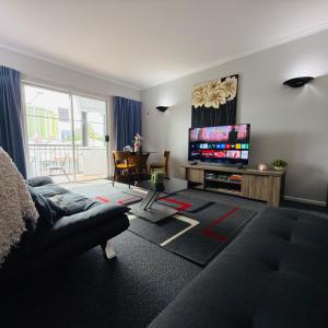 a living room with a couch and a flat screen tv at Villa on Grafton in Cairns +6 photos