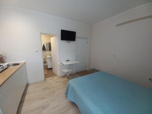 a small white room with a bed and a sink at KOD VELIKIH TUJA in Melenci
