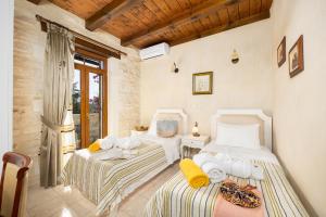 a bedroom with two beds and a table at Villa Marcos Chara in Astérion +20 photos