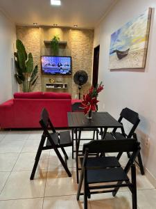 a living room with a table and a red couch at Casa Maresia Ponta da Asa in Coruripe