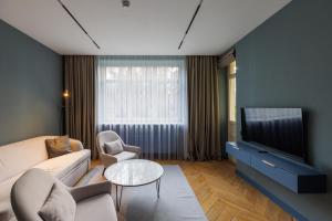 a living room with a couch and a tv at Lion's Castle Hotel in Lviv