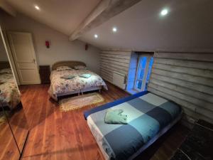 a bedroom with two beds and a wooden floor at Le balcon de Vernay in Vernay