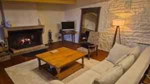 a living room with a couch and a fireplace at Le balcon de Vernay in Vernay